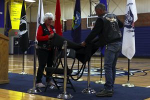 Two members of Rolling Thunder unveil the chair