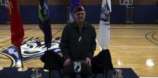 A veteran stands behind the POW/MIA chair
