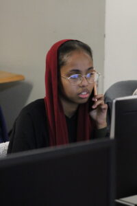 A student working on their fafsa while on the phone - by Deklin Fitzgerald
